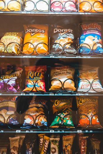 A shelf of snacks including Doritos and Ruffles.